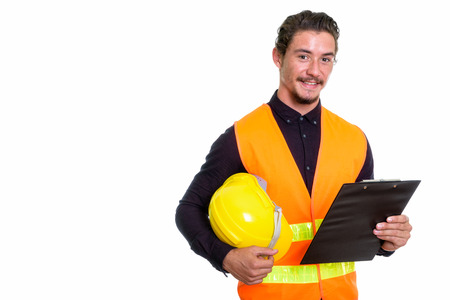 Studio shot of young happy man construction worker smiling while