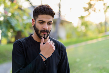 Young handsome Indian man thinkingの写真素材