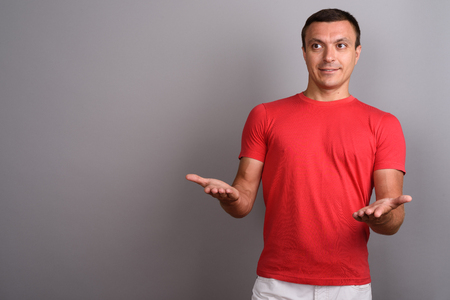 Man wearing red shirt against gray backgroundの写真素材