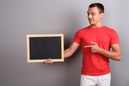 Man wearing red shirt against gray backgroundの写真素材