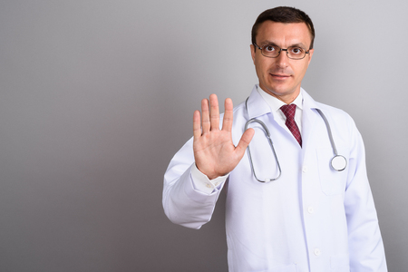 Man doctor wearing eyeglasses against gray backgroundの写真素材