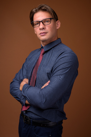 Studio shot of businessman against brown backgroundの写真素材