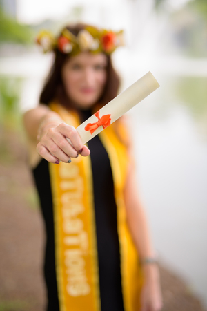 Young beautiful woman celebrating graduation at the park in Bangの写真素材