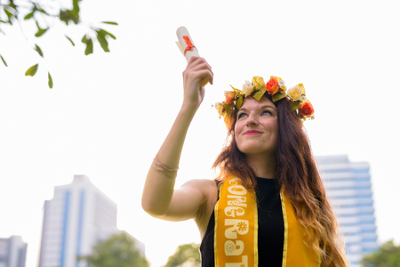 Young beautiful woman celebrating graduation at the park in Bangの写真素材