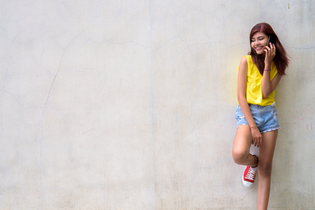 Beautiful teenager girl wearing vibrant yellow shirtの写真素材