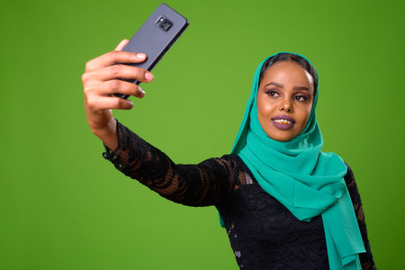 Young African Muslim woman against chroma key with green background