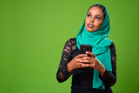 Young African Muslim woman against chroma key with green backgroundの写真素材
