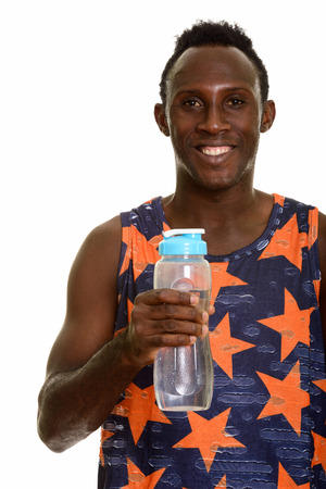 Young happy black African man smiling and holding water bottleの写真素材
