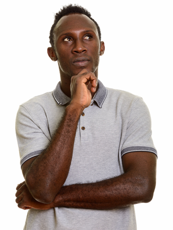 Young black African man thinking while looking upの写真素材