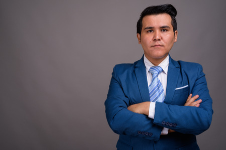 Young multi-ethnic businessman against gray backgroundの写真素材