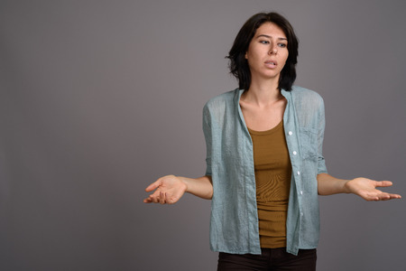 Young beautiful woman against gray backgroundの写真素材