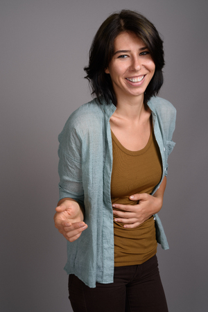 Young beautiful woman against gray backgroundの写真素材