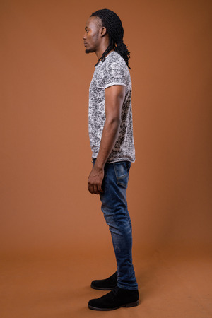 Young handsome African man against brown backgroundの写真素材