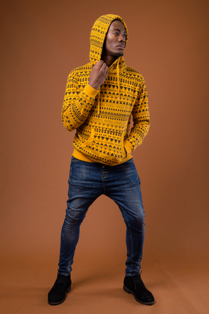 Young handsome African man against brown backgroundの写真素材