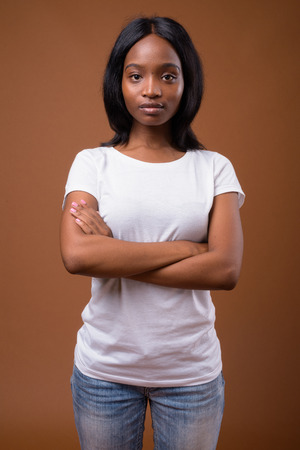 Young beautiful African Zulu woman against brown backgroundの写真素材