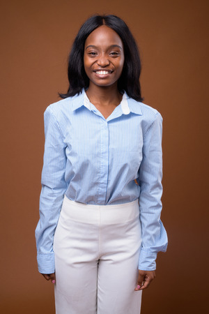 Young beautiful African Zulu businesswoman against brown backgroの写真素材