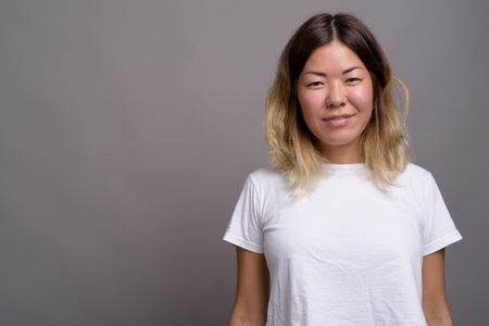 Young beautiful Kazakh woman against gray backgroundの写真素材