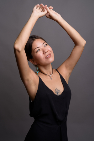 Young beautiful Kazakh woman against gray backgroundの写真素材