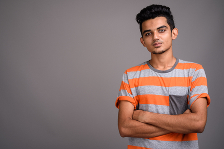Young Indian man against gray backgroundの写真素材