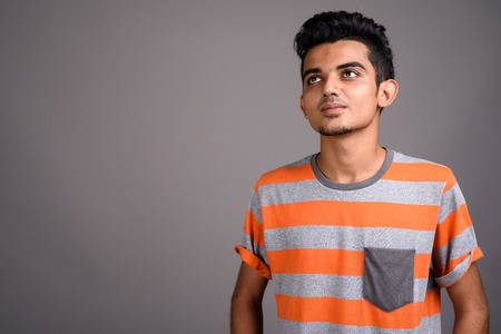 Young Indian man against gray backgroundの写真素材