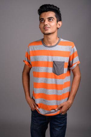 Young Indian man against gray backgroundの写真素材