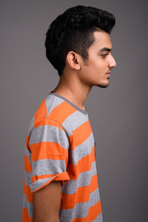 Young Indian man against gray backgroundの写真素材