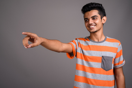 Young Indian man against gray backgroundの写真素材