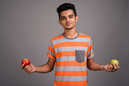 Young Indian man against gray backgroundの写真素材