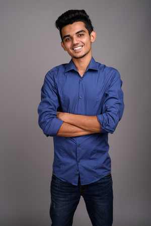 Young Indian businessman against gray backgroundの写真素材