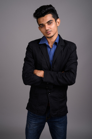 Young Indian businessman against gray backgroundの写真素材