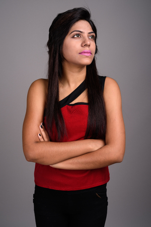 Young Indian woman against gray backgroundの写真素材