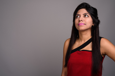 Young Indian woman against gray backgroundの写真素材
