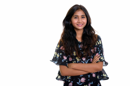 Studio shot of young happy Persian woman smiling with arms crossの写真素材