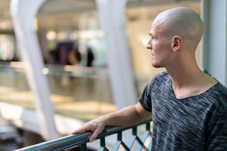 Profile view of young handsome bald man thinking on the foot briの写真素材