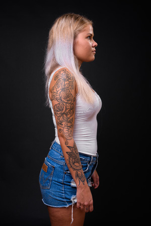 Young beautiful blonde woman against black backgroundの写真素材