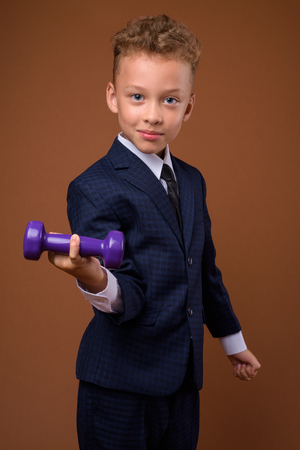 Young boy as businessman against brown backgroundの写真素材