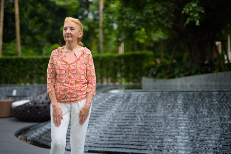 Beautiful senior tourist woman with blond hair relaxing around tの写真素材