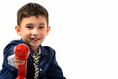 Studio shot of cute happy boy smiling and giving old telephone