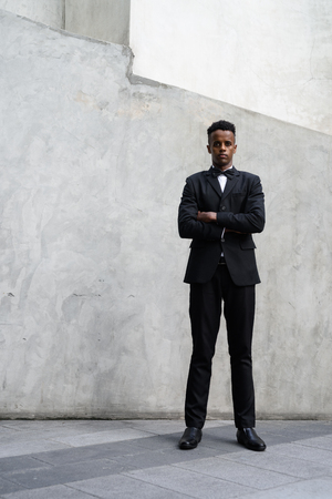 Young handsome African businessman wearing suit against concreteの写真素材