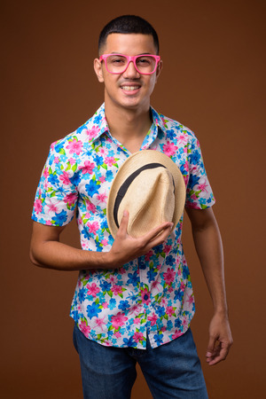 Young multi-ethnic Asian tourist man against brown backgroundの写真素材