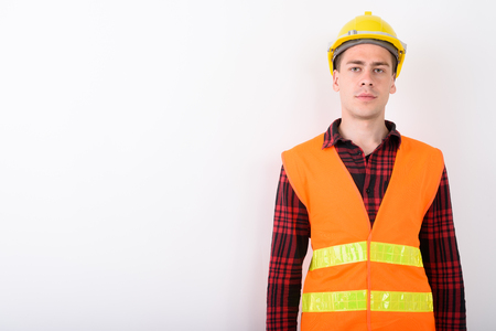 Young handsome man construction worker against white backgroundの写真素材