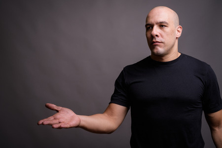 Handsome bald man against gray backgroundの写真素材
