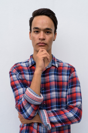 Young handsome Indian man against white wall in the streets outdの写真素材