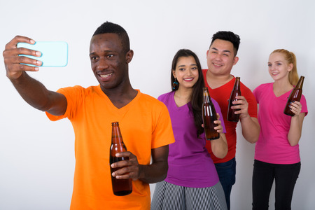 Studio shot of happy young African man with diverse group of mul