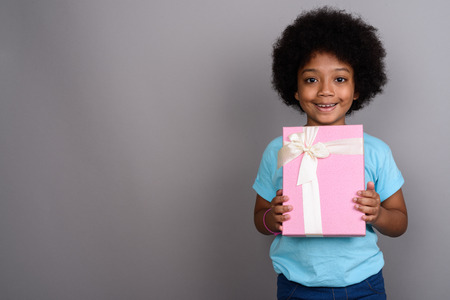 Young cute African girl against gray backgroundの写真素材