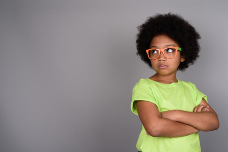 Young cute African girl against gray backgroundの写真素材