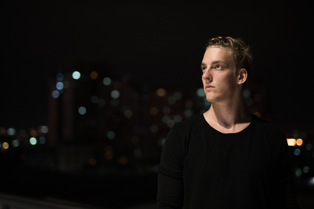 Young Handsome Man Thinking Outdoors At Nightの写真素材