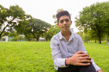 Portrait of young Indian teenage boy relaxing at the park in the city of Bangkok, Thailandの写真素材