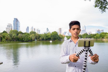 Portrait of young Indian teenage boy relaxing at the parkの写真素材