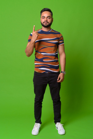 Young bearded Indian man against green backgroundの写真素材